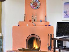 a living room with a fire place in the center and a tv on top of it