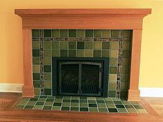 a fireplace in a living room with tile on the mantle and wood trimmings