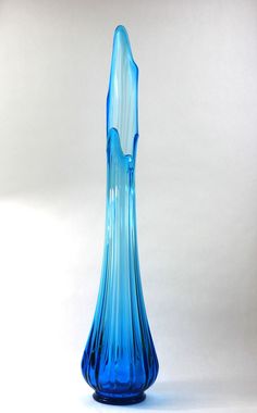 a blue glass vase sitting on top of a table