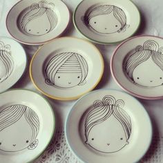 six plates with drawings of girls on them