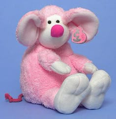 a pink stuffed animal sitting on top of a blue background