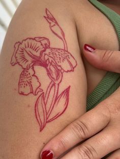 a close up of a woman's arm with a flower tattoo on her left side