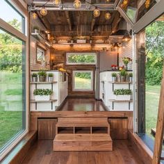 the interior of a tiny house with wood floors and windows, including an open kitchen area