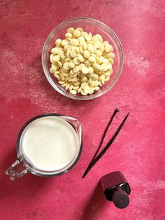 a blender filled with cereal and milk next to two other items on a pink surface