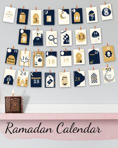 the rama calendar is hanging on a clothes line and next to a small box with candles