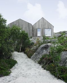 two wooden houses sitting on top of a rocky hillside