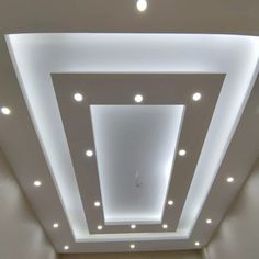 an empty room with white lights on the ceiling and recessed lighting in the ceiling