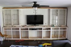 a living room filled with furniture and a flat screen tv on top of a wooden entertainment center