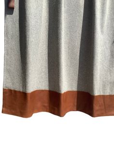 an orange and grey curtain hanging on the side of a window