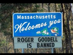 a blue sign that says welcome to roger goodell is banned in front of some trees