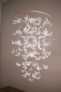 a wind chime with white butterflies hanging from it's centerpiece in a room