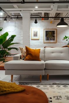 a white couch sitting in the middle of a living room next to a table and potted plants