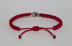 Fashionable and durable hand-made red string Hamsa Hand bracelet with an evil eye for wrist sizes 6 inches to 9 inches, with an easy to use zip like function to fit your wrist. Made from high quality red string, it will be sure to last. The Hamsa Hand is an ancient Middle Eastern amulet symbolizing the Hand of God. In all faiths it is a protective sign. It brings its owner happiness, luck, health, and good fortune. Each bracelet is carefully handcrafted and give proper time to ensure quality. Fa Adjustable Red Evil Eye Bracelet, Hand-strung, Adjustable Red Evil Eye Bracelet Hand-strung, Handmade Spiritual Red Braided Bracelets, Red Braided Bracelet With Evil Eye For Gift, Handmade Red Spiritual Braided Bracelets, Red Evil Eye Braided Bracelet Gift, Handmade Red Spiritual Braided Bracelet, Red Handmade Spiritual Braided Bracelet, Red Braided Evil Eye Bracelet