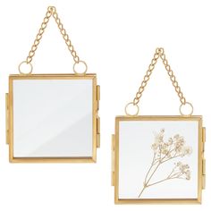 two mirrors hanging from chains with flowers on them, one is gold and the other is white