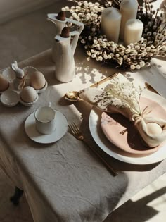 the table is set with dishes, cups and saucers