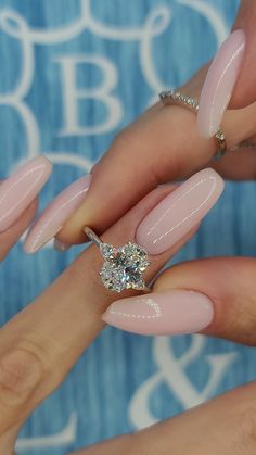 a woman's hands with pink manies and a diamond ring on her finger