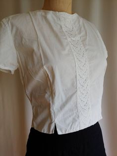 An iconic 50s 60s era blouse in a crisp pure white cotton Adorable high quality cut out lace inset in front Two front slits provide more movement Darts give this blouse ample bust roominess Shorter cropped style No label Bust - 20 inches Waist - 32 - 34 inches Back - 14 inches Length - 18 inches Excellent vintage condition Clean and ready to wear The pure cotton skirt it is photographed with can be found here: 50s Blouse, Lace Inset, Cropped Style, Cotton Skirt, Asian Style, Green Cotton, Body Size, Pure White, Golf Shirts