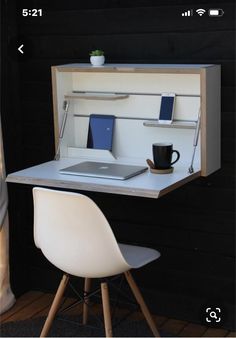 a desk with a laptop on it and a chair next to it