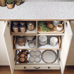 an open cabinet in a kitchen filled with dishes