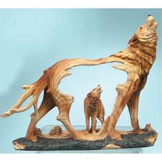 a wooden carving of two wolfs on a rock base