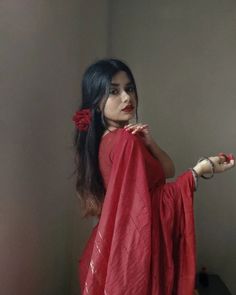 a woman in a red sari is posing for the camera with her hand on her hip