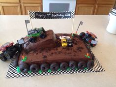 a birthday cake made to look like a race track with trucks and cars on it