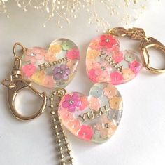 two heart shaped key chains with flowers on them