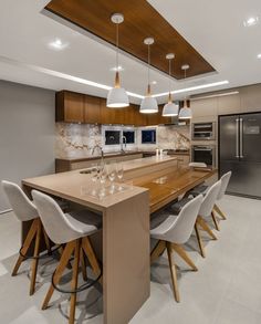 a modern kitchen with an island table and bar stools