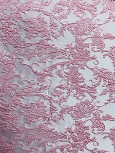 pink and white lace fabric with floral design on the bottom, as well as an intricately detailed pattern