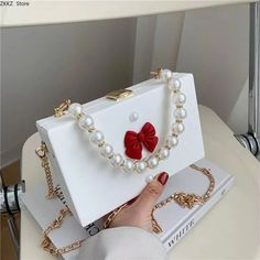 SPECIFICATIONS Brand Name: LIZAKOSHT Handbags Type: Shoulder Bags Main Material: PVC Lining Material: SATIN Shape: Box Hardness: HARD Pattern Type: Bow Decoration: Beading Decoration: Bow Gender: WOMEN Style: fashion Number of Handles/Straps: two Pearl Bow, Beaded Boxes, Box Bag, Square Bag, Chanel Boy Bag, White Bag, Metal Chain, Cross Body Handbags, Cute Dresses