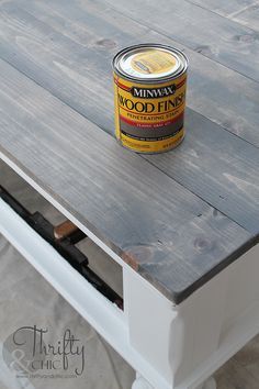 a can of food is sitting on top of a white table with drawers underneath it