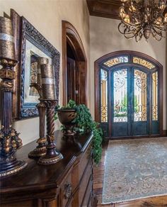 the entryway to this home is decorated in wood, glass and wrought iron doors