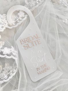 the bridal suite tag is laying on top of white veils and lace,