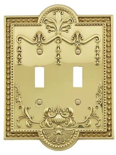 an ornate light switch cover in gold