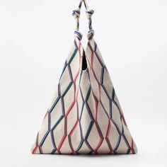 a white bag with red, blue and green lines on the front is hanging from a string