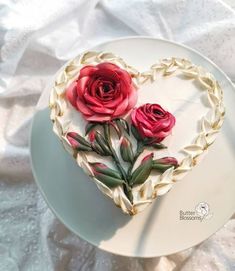 there is a heart shaped cake with roses on it and leaves in the shape of a heart