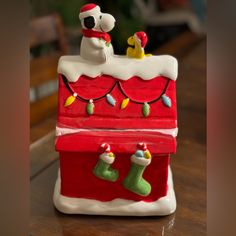 a red and white christmas cake with stocking on it's sides sitting on top of a wooden table