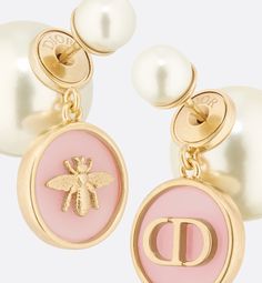 The Dior Tribales earrings are a modern creation enriched with symbols cherished by Mr. Dior. The asymmetrical design's iconic pearls unveil a hydrangea pink transparent resin medallion adorned with the CD signature on one side and a bee on the other. The refined gold-finish metal earrings can be paired with creations from the D-Luck line.. Luxury Pearl Earrings, Luxury Rose Gold Pearl Drop Earrings, Luxury Rose Gold Drop Pearl Earrings, Dior Earrings Pearl, Dior Stud Earrings, Dior Earrings Studs, Dior Jwellary, Dior Earing Pearl, Hydrangea Pink