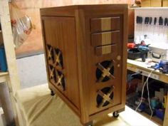 a wooden cabinet sitting on top of a table next to a workbench and tools