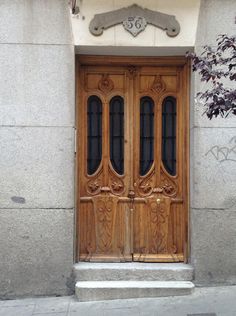 an ornate wooden door on the side of a building