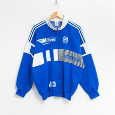 Vintage 80's Adidas track jacket with a front zip - in blue-white - features IFK Karlshamn logos - logo on the chest - 2 outer pockets - material: 85% polyester, 15% cotton SIZE: D 7, USA L, F 186, GB 42/44 MEASUREMENTS chest circumference: 53.5 inches (136 cm) length: 27 inches (68 cm) sleeve length from the neck: 31 inches (79 cm) The model is 6'1" (186 cm), measures 41-35-39 (104-88-100 cm) and typically wears clothing in size L CONDITION - 9/10 - Great pre-owned vintage condition. Washed, re Vintage Track Jacket, Team Jackets, Adidas Vintage, Adidas Track Jacket, Adidas Track, Track Jacket, Track Jackets, Blue Man, Poland