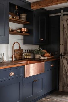 a kitchen with dark blue cabinets and copper accents