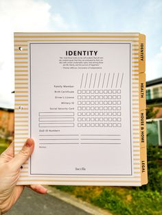 a person holding up a paper with the word identity on it in front of a house