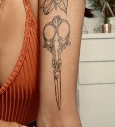 a woman with a tattoo on her arm holding a pair of scissors