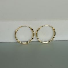 14mm sterling silver endless ear hoops, plated in gold. Size: 1.2 x 14 mm Gauge: 16 These earrings are made of real 925 hypoallergenic sterling silver, dipped in real gold. Price listed is for ONE PAIR of hoops. These earrings are made of 925 hypoallergenic sterling silver and comes with a 925 stamp. Can be packaged in a gift box. I can include a personal message from you if needed You are welcome to contact me at... bhavnakwintra1956@gmail.com For more beautiful pieces from my shop, please brow Simple Adjustable Gold Cartilage Earrings, Adjustable Round Hoop Earrings In Dainty Style, Dainty Round Hoop Earrings, Adjustable Minimalist Small Hoop Nose Rings, Adjustable Dainty Hoop Earrings, Adjustable Gold Nose Rings For Everyday, Minimalist Adjustable Small Hoop Nose Rings, Dainty Hypoallergenic Hoop Cartilage Earrings, Dainty Round Hoop Earrings With Simple Design