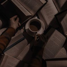 someone is holding a cup of coffee and reading books