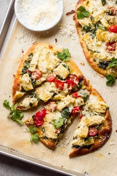 two pizzas sitting on top of a pan covered in toppings