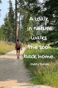 a woman walking down a dirt road with a backpack on her back and the words, a walk in nature walks the soul back home