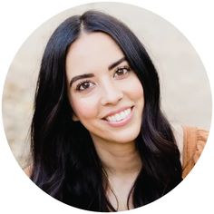 a woman with long black hair smiling at the camera in a round photo frame on a white background