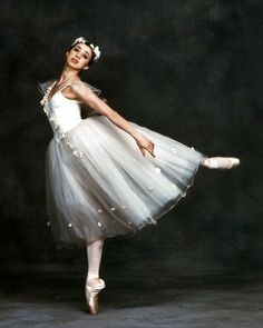 a young ballerina is posing for the camera